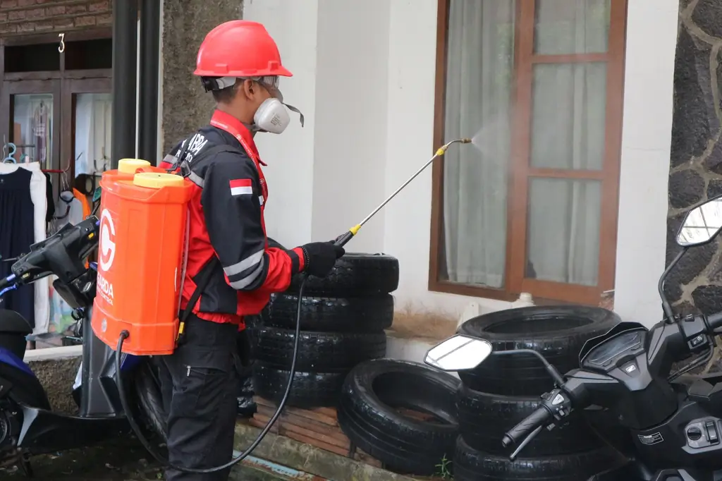 Sırt pompasıyla ilaçlama yapan koruyucu ekipmanlı uygulayıcı