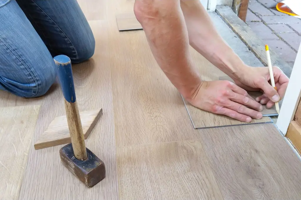 Laminat parkeyi ölçüp keserek döşeyen usta