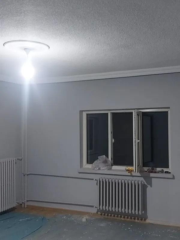 Duvar ve tavan boyası bitmiş, zemini naylonla örtülü oda