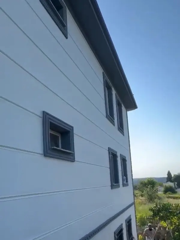 Gri ve beyaz tonlarda boyanmış çok katlı binanın dış cephesi