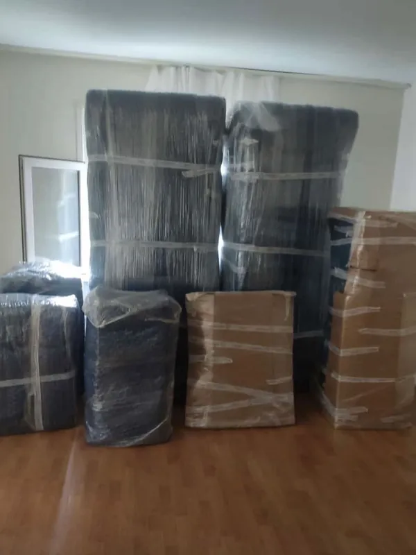 Boş odada paketlenmiş koliler ve sarılmış mobilyalar
