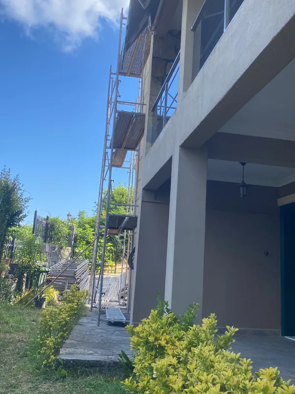 Dış cephesinde iskele kurulu, sıvası yapılmış iki katlı bina