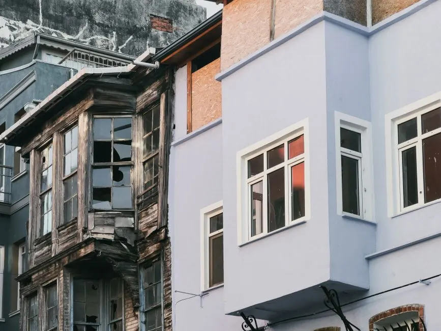 Çürüyen ve modern kentsel bina dış cepheleri arasında keskin bir kontrast.