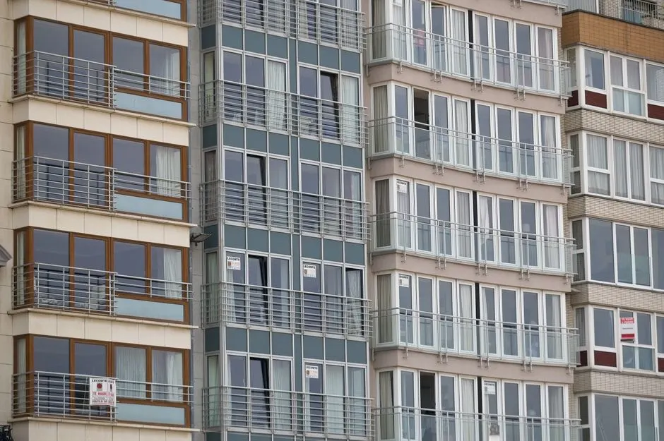 Büyük pencerelere sahip modern bir konut binasının cephe detaylı yakın görünümü.