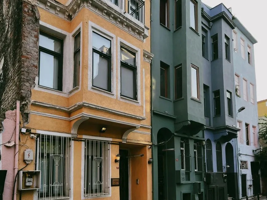 Şehirdeki canlı sıra ev cepheleri, kentsel mimari ve yenilemeyi sergiliyor.