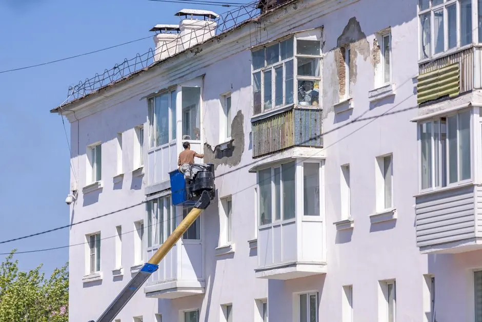 Sepetli platformdan apartman cephesini boyayan usta